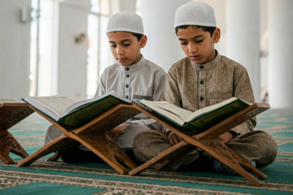 Two young boys memorizing the Quran (Hifz) while reading from open Mushafs in a mosque.